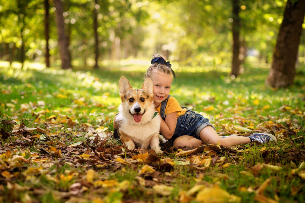 Dziewczynka przytulająca się do psa rasy corgie